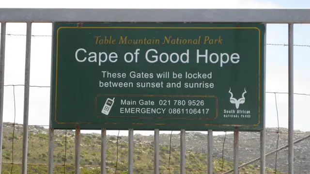 A green Cape of Good Hope sign is fixed to a gate.