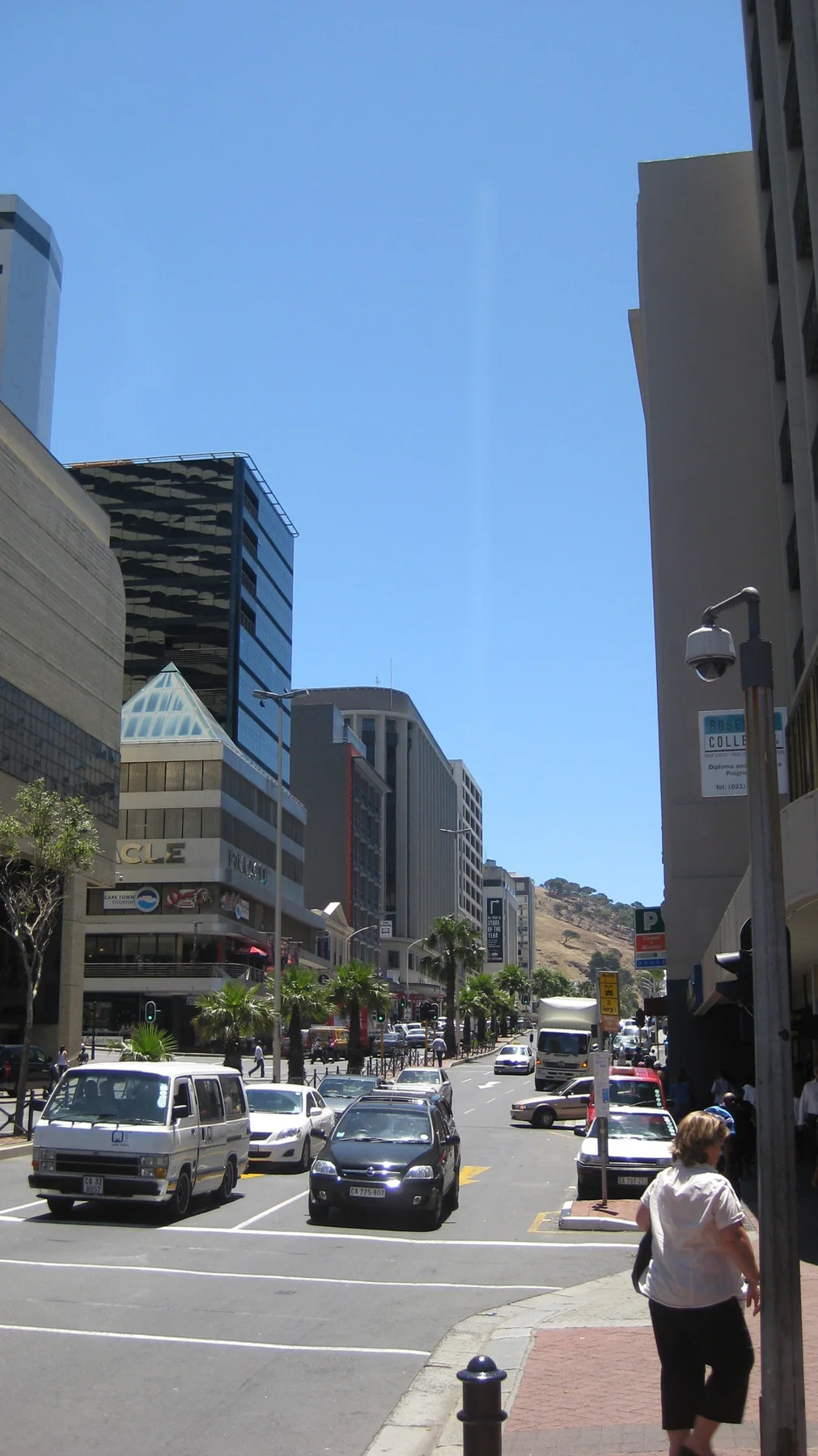 Tall buildings flank a narrow view down a busy street.