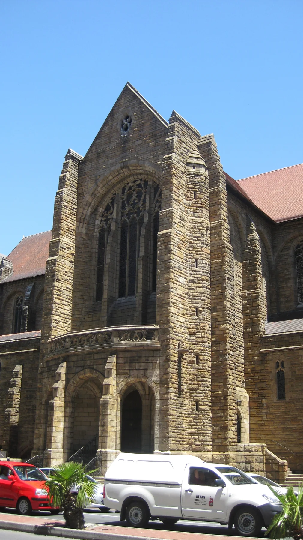 A stone church facade has a tall pointed window above its entrance.