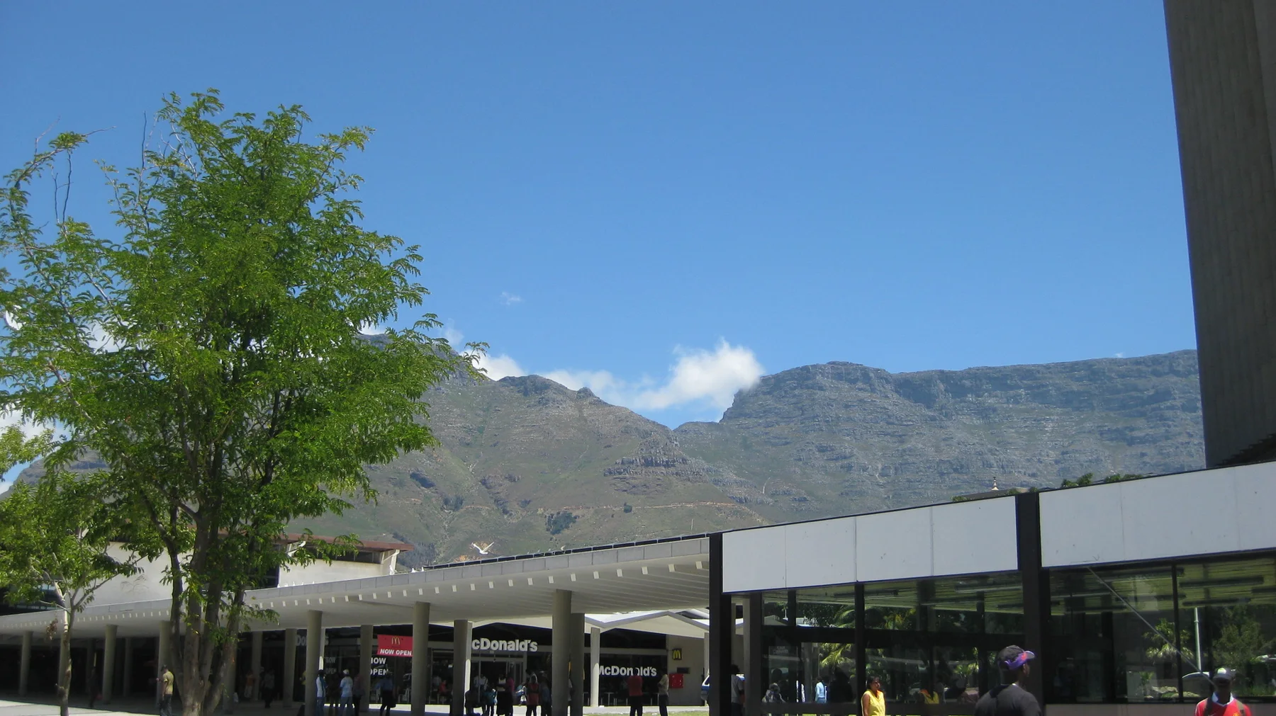 A mountain ridge rises beyond a low commercial roof.
