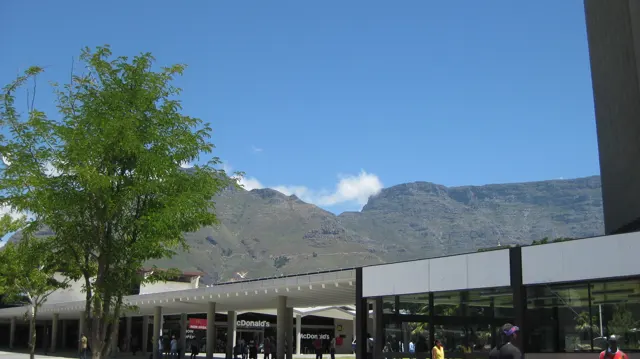 A mountain ridge rises beyond a low commercial roof.