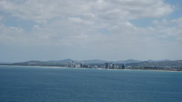 Distant waterfront towers line a broad blue bay.