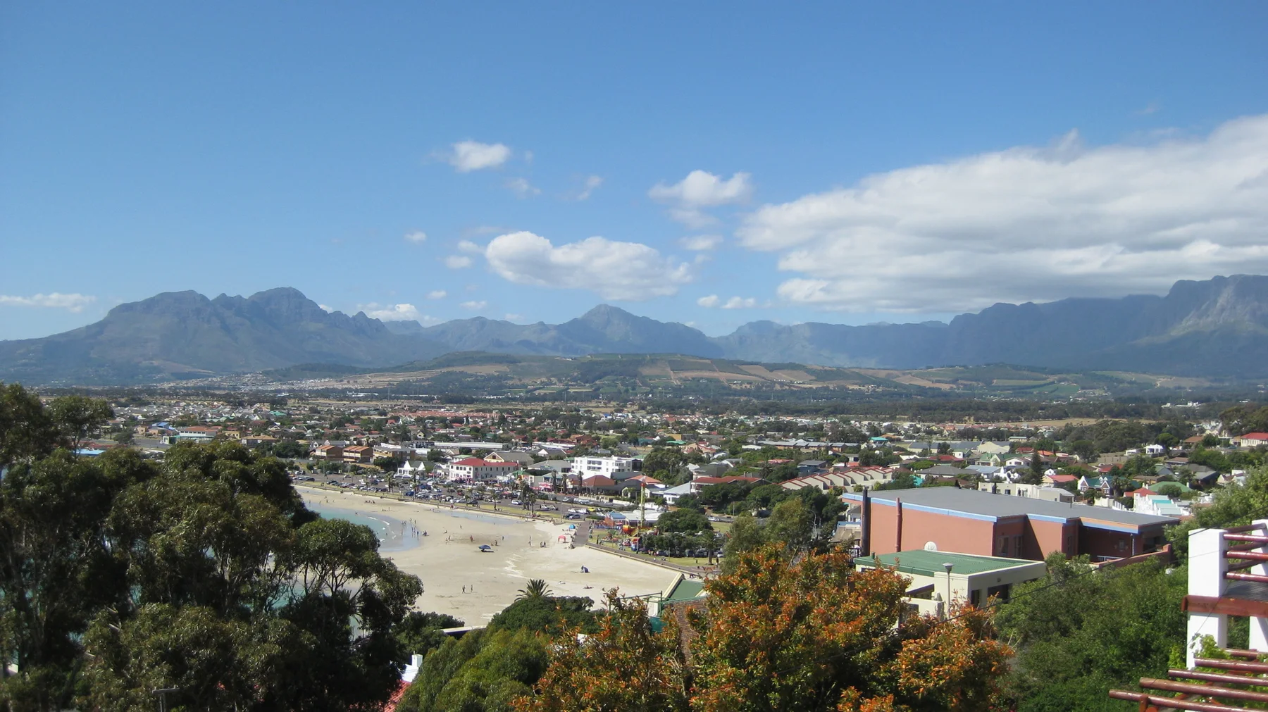 Town buildings spread below distant mountains and white clouds.
