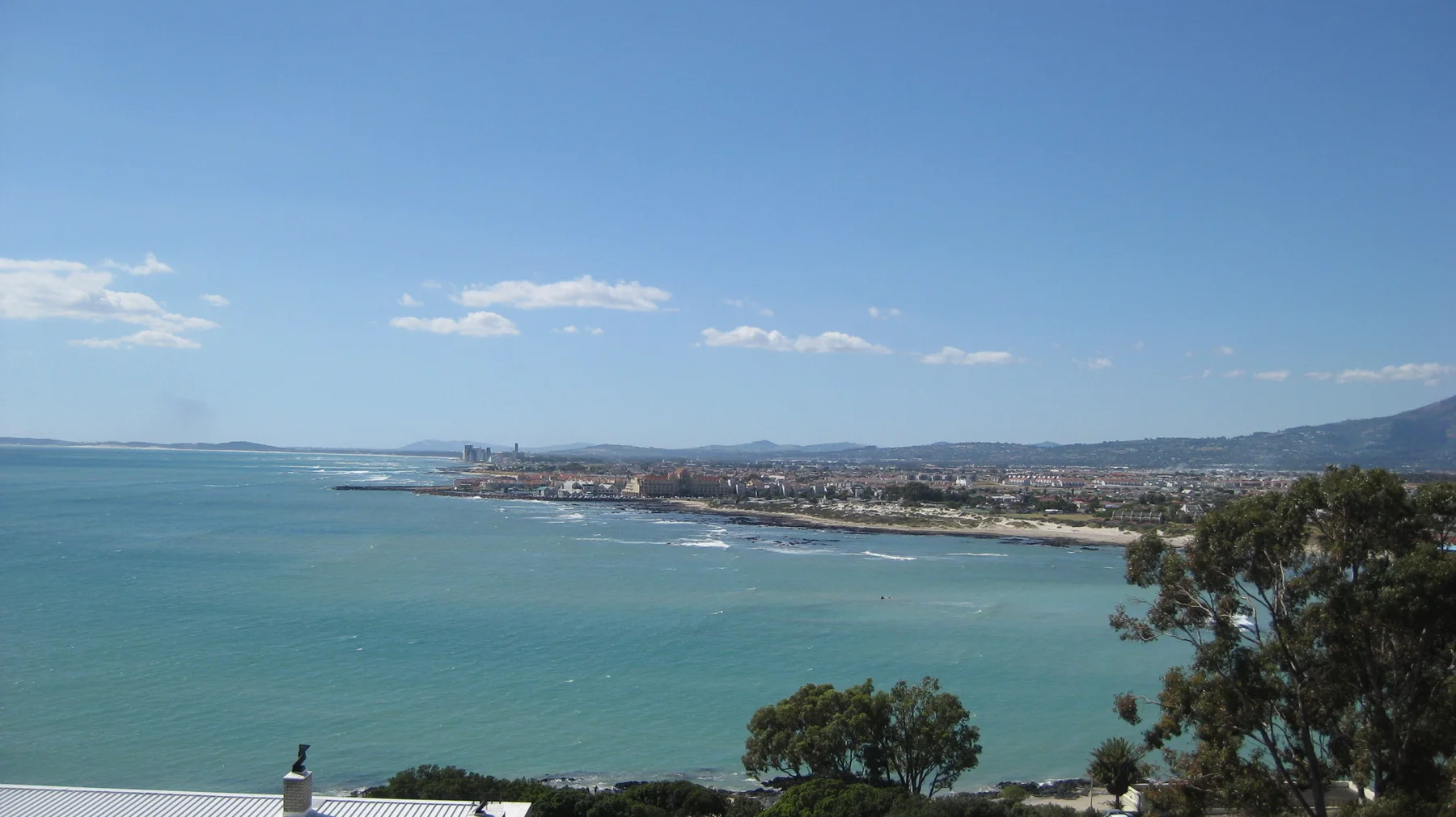 A long developed shore stretches across turquoise water.