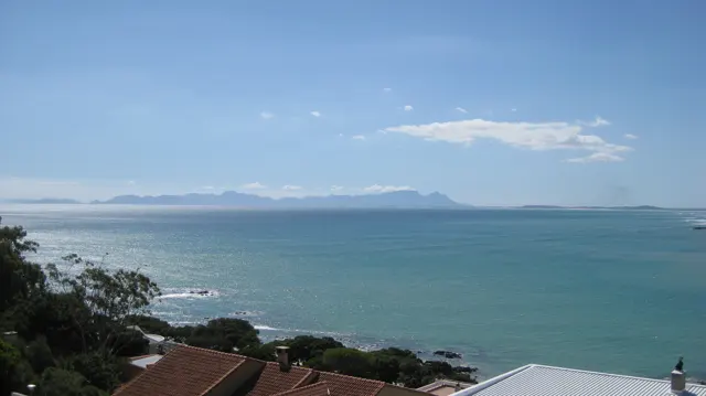A flat distant ridge appears across pale blue water.