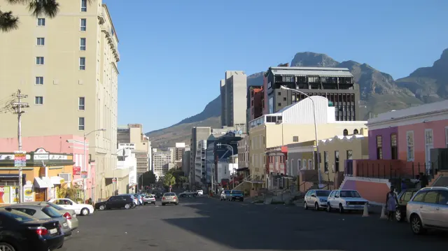 A busy street runs between colorful low facades and taller buildings.