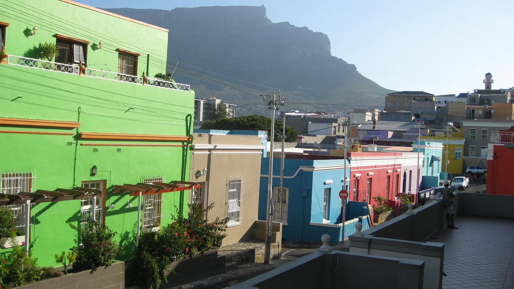 A mountain rises beyond a descending street of colorful houses.