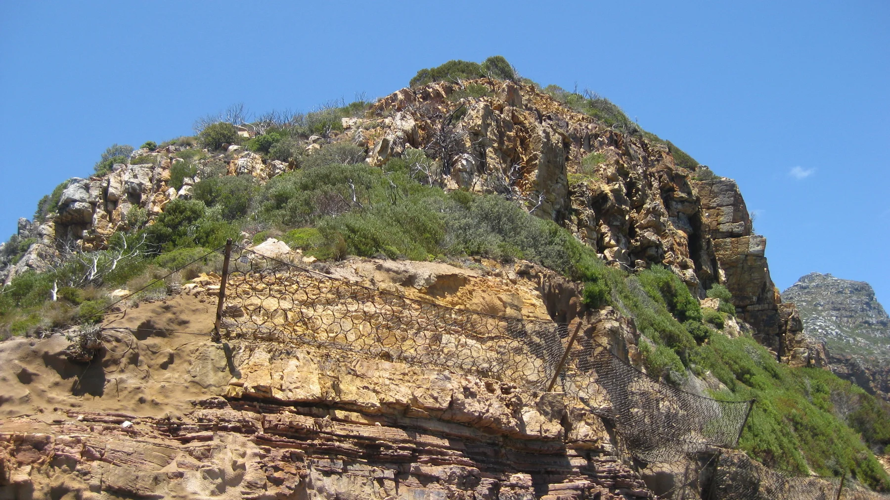 Broken layers of ochre-coloured rock rise against the sky.