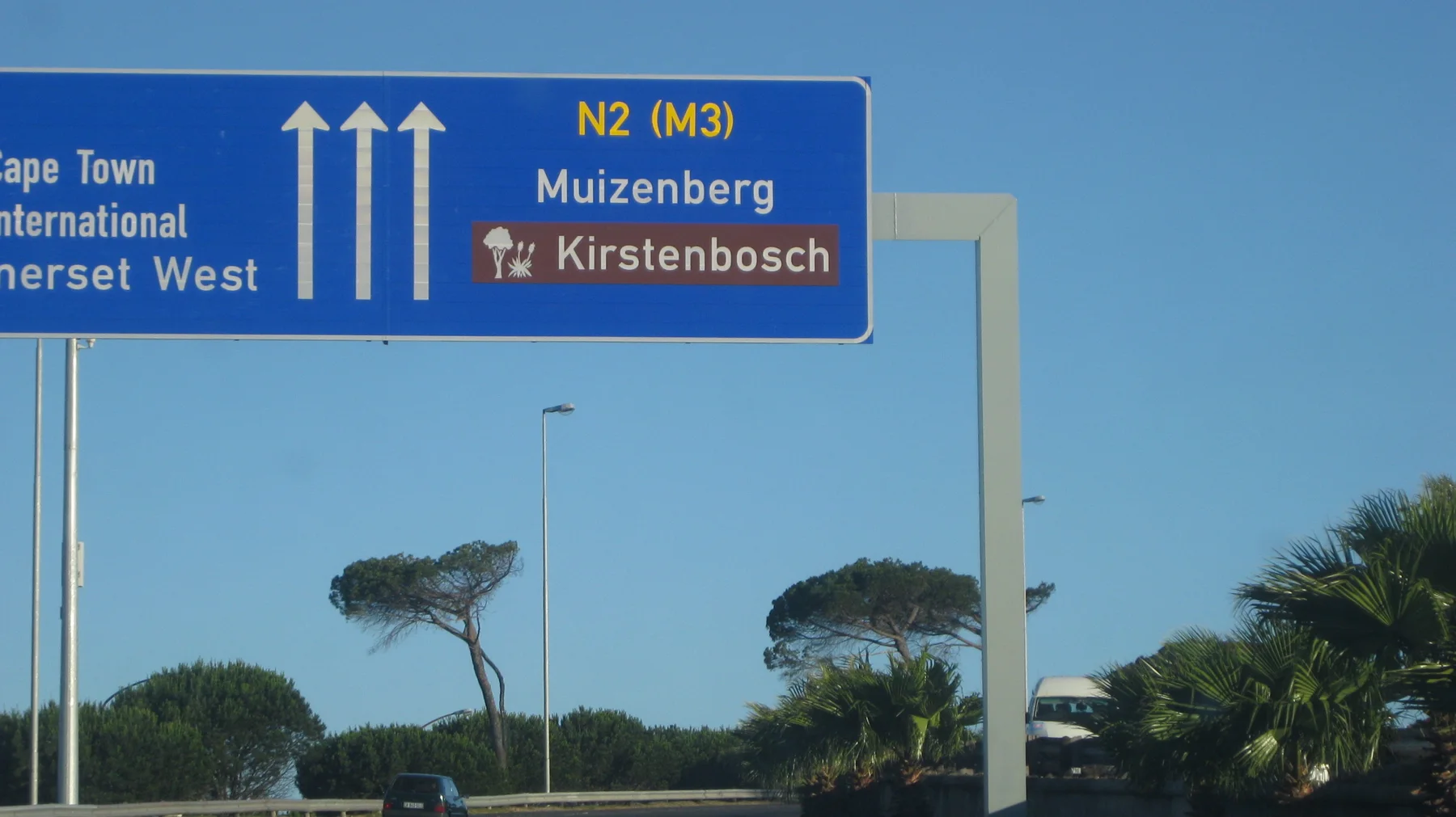 An overhead sign directs traffic toward Muizenberg and Kirstenbosch.