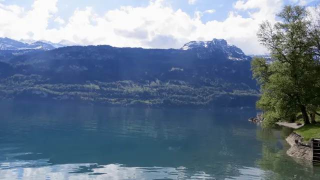 A dark mountain ridge with snow near its top rises across the lake.