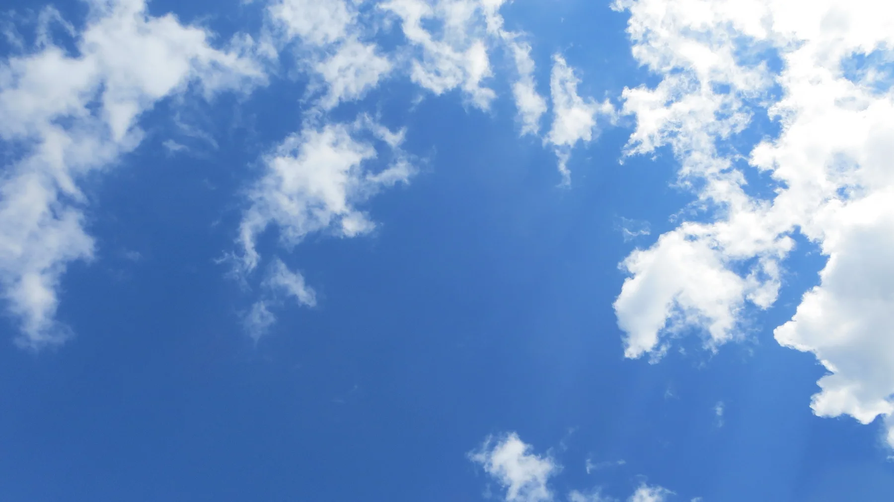 Soft white clouds spread across a clear blue sky.