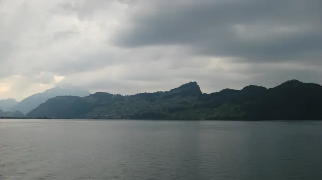 A long, uneven mountain ridge stretches across the far side of a gray lake.