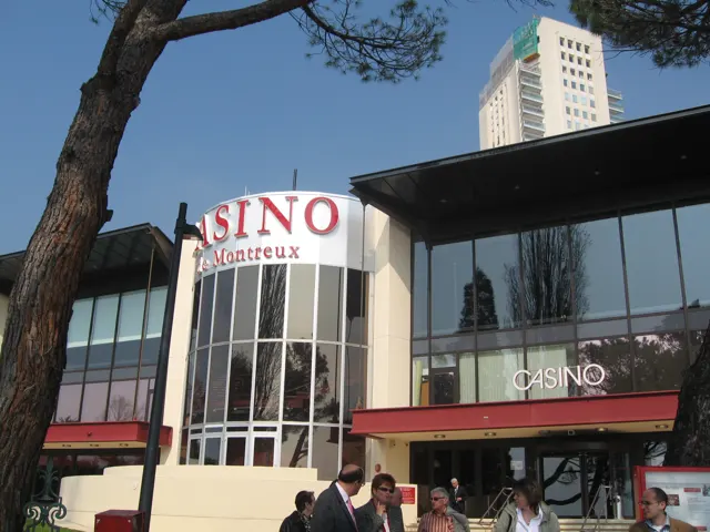 People stand near the glass-fronted entrance of a building marked Casino.