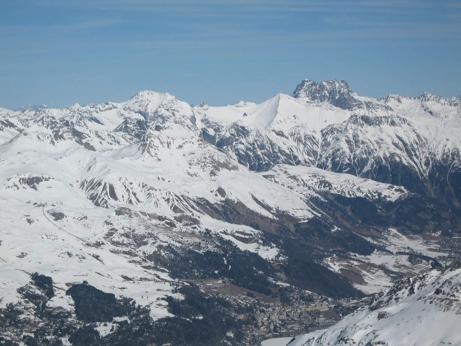 A long valley winds between extensive snow-covered mountain ranges.