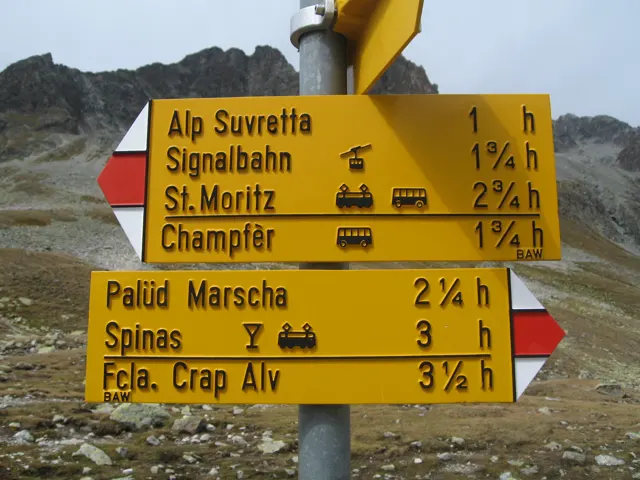 Yellow hiking signs list destinations including Alp Suvretta, St. Moritz and Spinas.