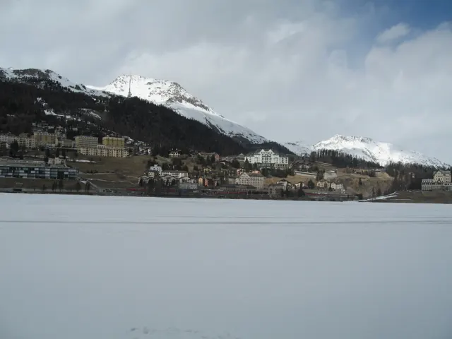 A hillside town stretches across the far shore of a wide frozen lake.