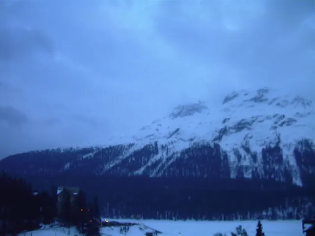 Low blue-gray cloud partly conceals a snowy mountain above the valley.